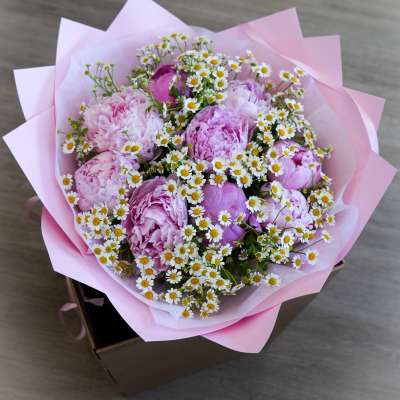 Pink peony bouquet with small white daisies in pink wrapping