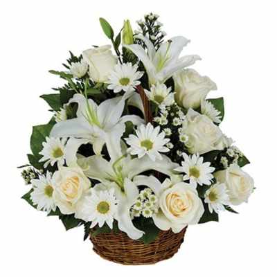 White lilies, roses, and daisies arranged in a wicker basket