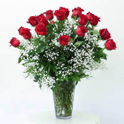 Red roses and baby's breath in a clear glass vase