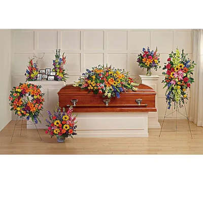 Colorful funeral casket spray with standing floral arrangements
