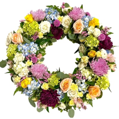Circular floral wreath with roses, chrysanthemums, hydrangeas, and mixed blooms