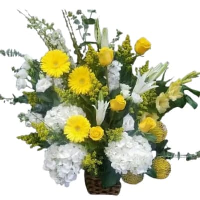 Yellow and white mixed flower arrangement in a woven basket