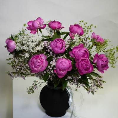 Pink peony bouquet in a black vase with white filler flowers
