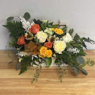 Mixed bouquet with orange, yellow, and white roses in a wooden box