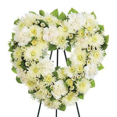 Heart-shaped white floral wreath on a stand