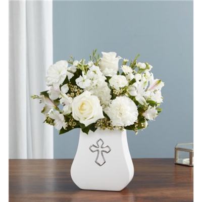 White floral arrangement in a vase with a cross emblem