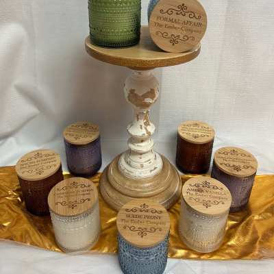 Assorted scented candles in textured glass jars on a pedestal stand
