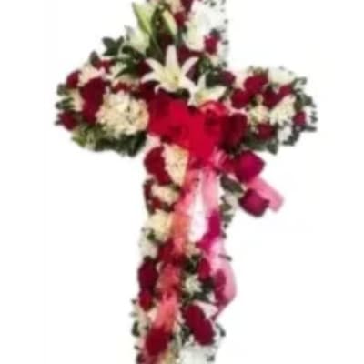 Heart-shaped floral arrangement with red and white flowers and pink ribbons