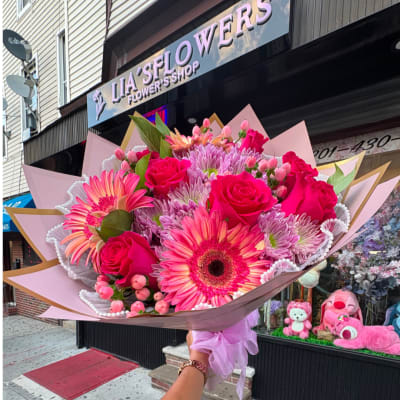 Pink mixed bouquet with roses and gerbera daisies wrapped in pastel paper