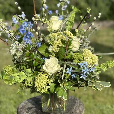 Blue and white floral arrangement in a clear glass vase