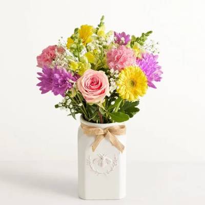 Mixed bouquet in a white vase with a burlap bow