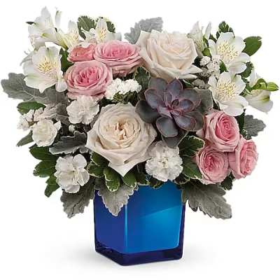 Pink and white rose bouquet in a blue glass vase