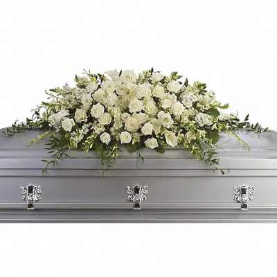 White floral casket spray on a silver casket