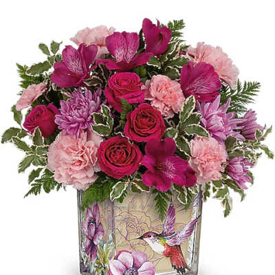 Pink and purple bouquet in a square glass vase with bird artwork