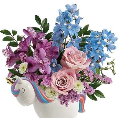 Pink and blue flowers arranged in a unicorn-shaped ceramic container