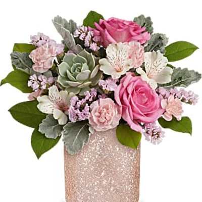 Pink and white floral arrangement in a glittery vase
