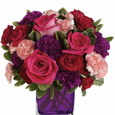 Bouquet of pink, red, and purple flowers in a purple glass vase
