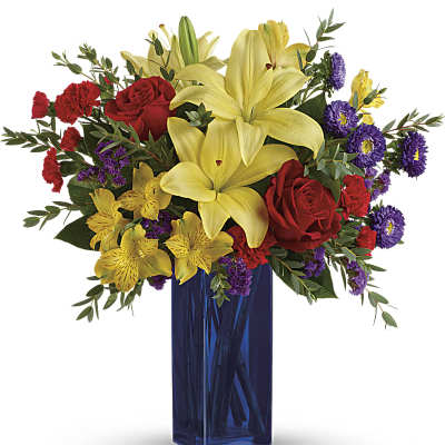 Bouquet of yellow lilies, red roses, and purple flowers in a blue vase