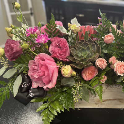 Pink and peach floral arrangement in a wooden box with a succulent center