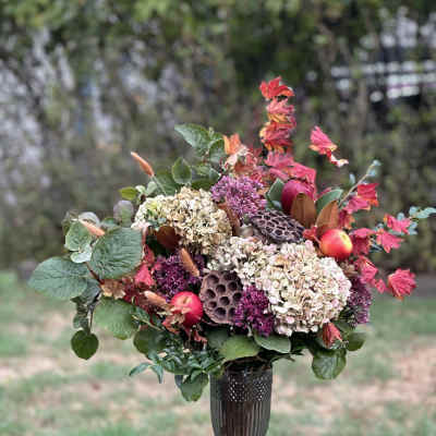 Autumn floral arrangement with hydrangeas and berries in a dark vase