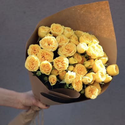 Bouquet of yellow roses wrapped in brown paper