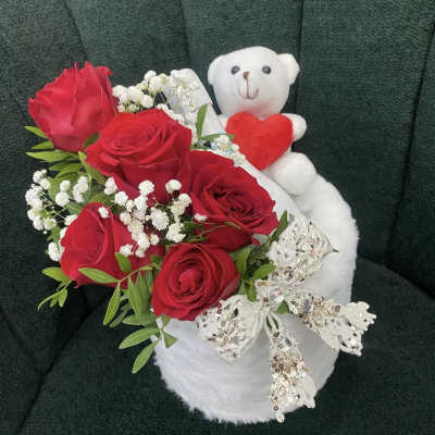 Red roses with baby's breath and a white teddy bear holding a heart