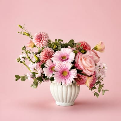 Pink mixed flowers arranged in a white vase