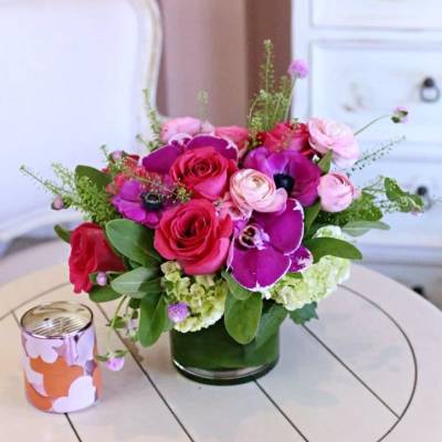 Pink and purple floral arrangement in a glass vase on a table