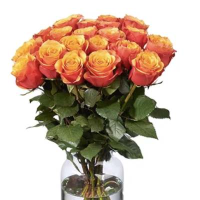 Bouquet of orange and yellow roses in a clear glass vase