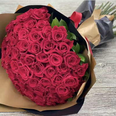Large bouquet of hot pink roses wrapped in brown and black paper
