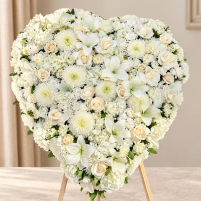 Heart-shaped white floral arrangement on a stand