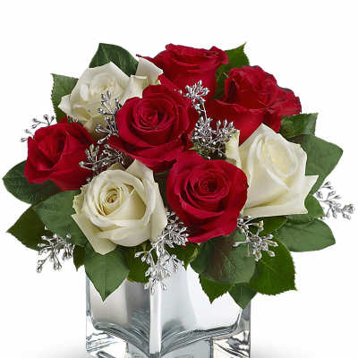 Red and white roses in a clear square vase