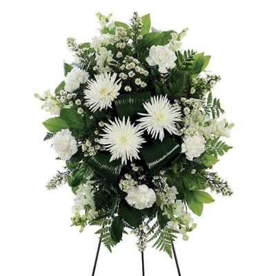White floral standing spray with daisies and carnations on a black easel