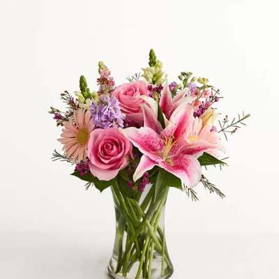 Pink roses and lilies in a clear glass vase