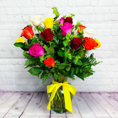 Mixed roses in a glass vase tied with a yellow ribbon