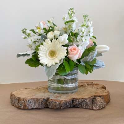White and blush flower arrangement in a glass vase