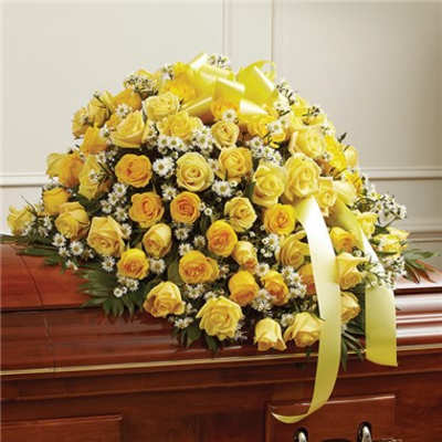 Yellow rose casket spray with white filler flowers and ribbon