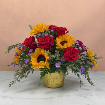 Bouquet of red roses and yellow sunflowers in a yellow vase