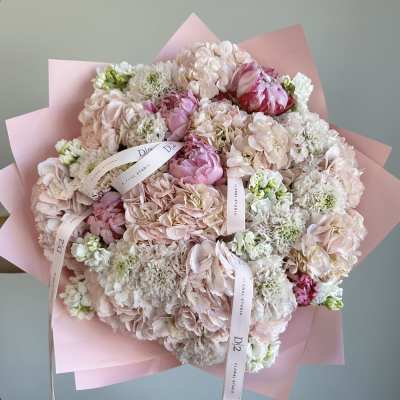 Large pastel bouquet of pink and white flowers wrapped in pink paper