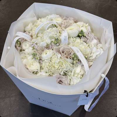 Bouquet of white and blush flowers wrapped in white paper