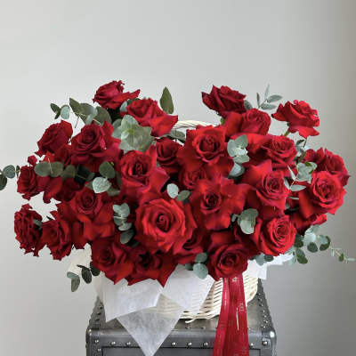 Basket of red roses with eucalyptus