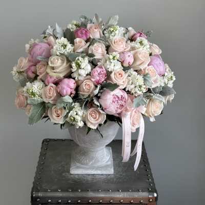 Pink and white rose bouquet in a gray pedestal vase