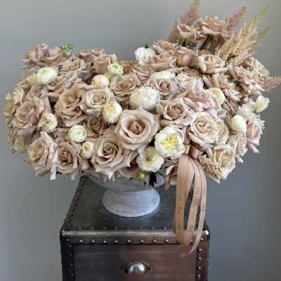 Blush rose arrangement in a gray pedestal vase with ribbon