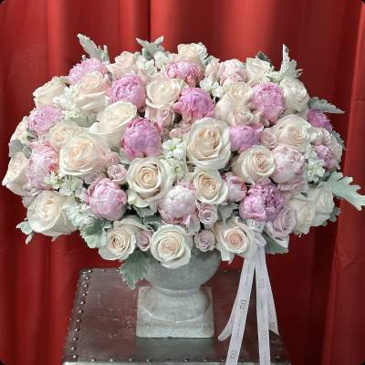Large bouquet of pale pink and white roses in a gray vase