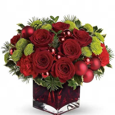 Red roses and green mums in a red glass vase with holiday ornaments