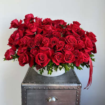 Large bouquet of red roses in a white bowl vase