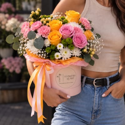 Pink and yellow mixed bouquet in a round pink box with ribbon