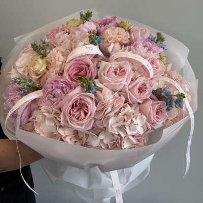 Bouquet of pink roses and hydrangeas wrapped in white paper