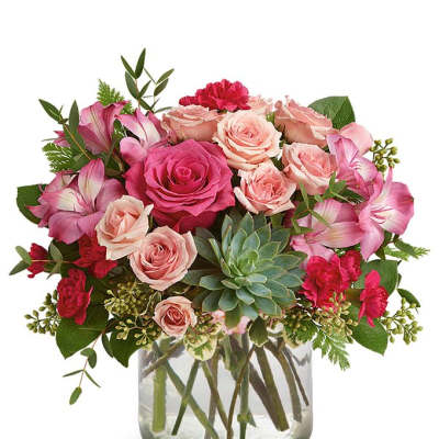 Pink roses and carnations in a glass vase with a succulent accent
