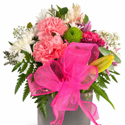 Pink and white mixed bouquet in a gray vase with a bright pink bow